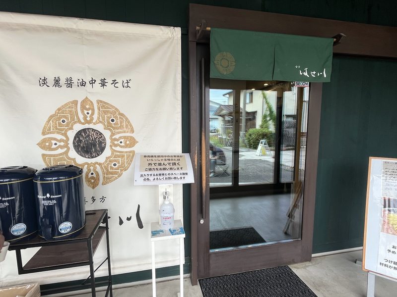 「淡麗醤油中華そば」の白い幕と緑ののれんが掛かる入口